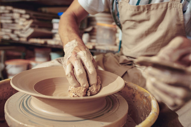 Creating a jar or vase of white clay close-up. Master crock. Man hands making clay jug macro. - Фото, изображение