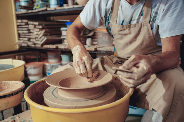 Creating a jar or vase of white clay close-up. Master crock. Man hands making clay jug macro. - Photo, image