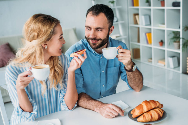 happy couple drinking coffee together in morning at home - Foto, Imagem