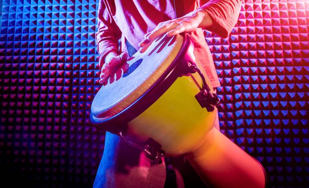 Young man playing on djembe in sound recording studio. African drums - Fotoğraf, Görsel