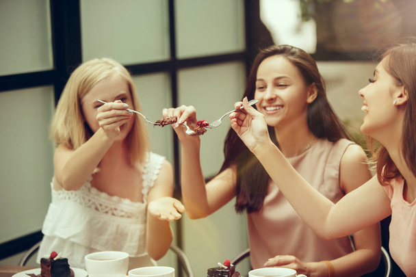 Two girl friends spend time together drinking coffee in the cafe, having breakfast and dessert. - Φωτογραφία, εικόνα