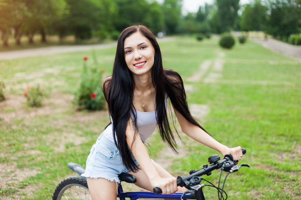 Gyönyörű lány, lovaglás kerékpár a Városligetben. Aktív emberek. A szabadban - Fotó, kép