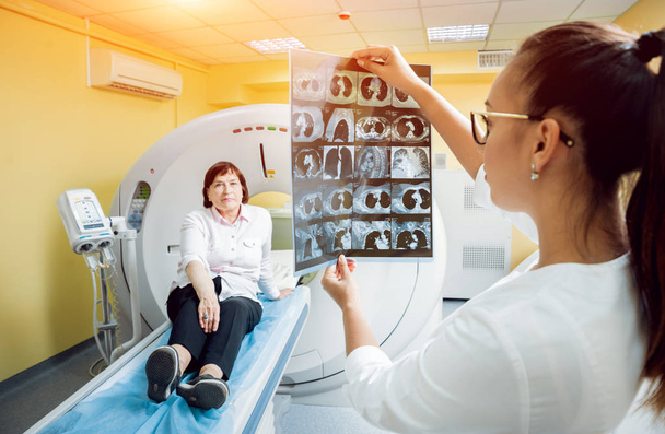 Radiologist with an elderly female patient looking at x-ray. Background - Foto, Bild