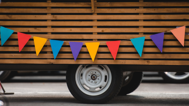wheels and bottom part of food truck with colorful flags  - Photo, Image