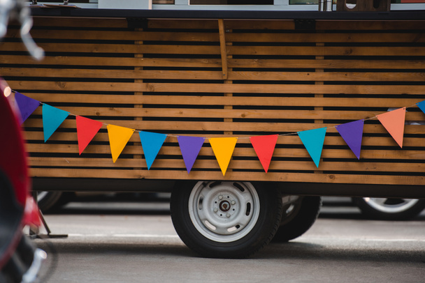 wheels and bottom part of food truck with colorful flags  - Photo, Image