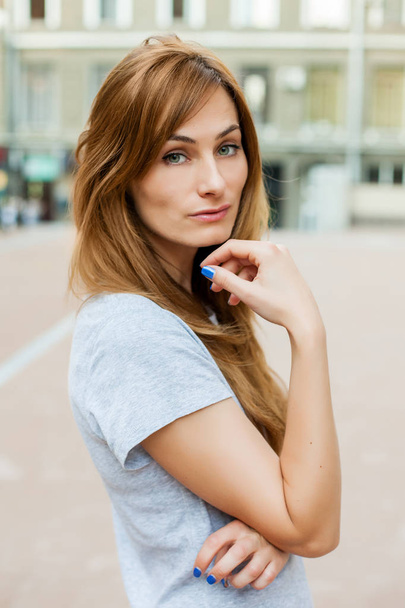 young thoughtfull redhead model walking around city - Foto, Bild