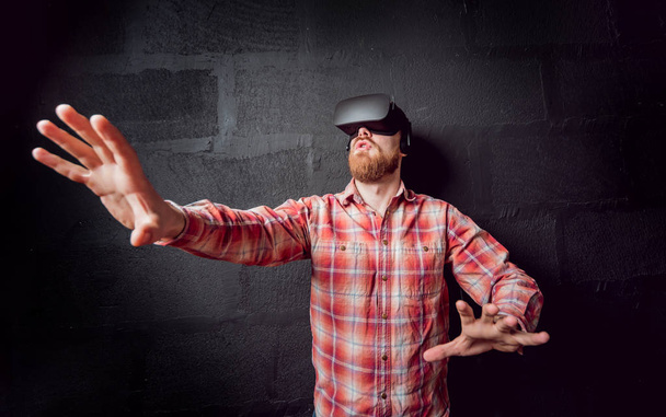 Young beardy man wearing virtual reality goggles at the office - Фото, зображення