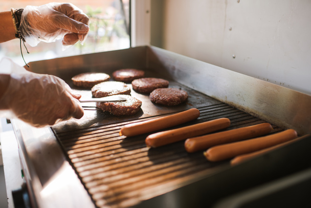 immagine ritagliata dello chef che prepara carne per hamburger nel camion alimentare
 - Foto, immagini