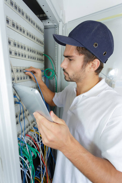 focused electrician applying safety procedure while working on electrical panel - Zdjęcie, obraz