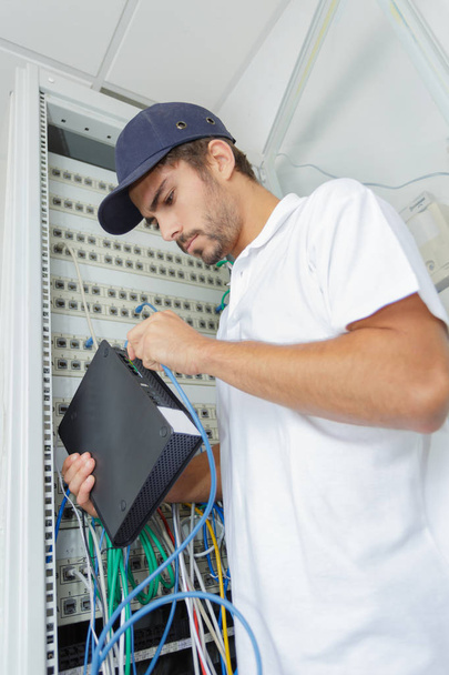 electricista conectar el servidor de Internet a la placa de alimentación - Foto, imagen