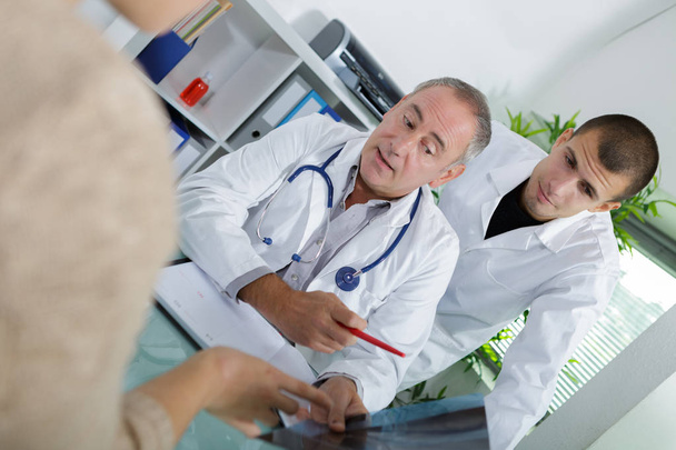doctor sitting with male patient at the desk - Fotó, kép