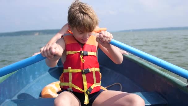 El tipo flota en el barco. Adolescente opera independientemente un barco con la ayuda de remos. Deporte extremo
 - Metraje, vídeo