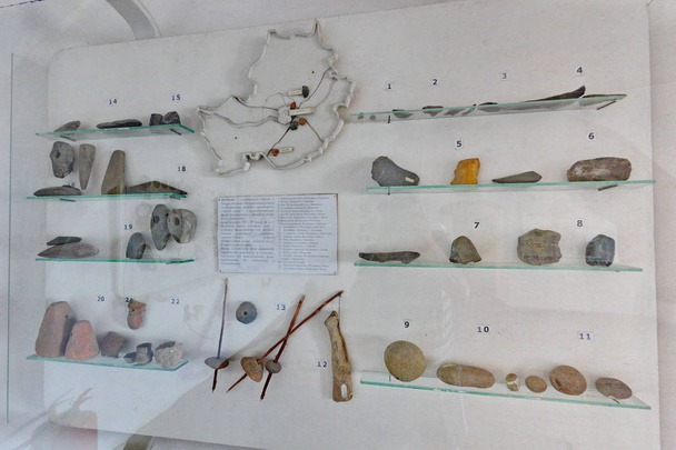 Museum exposition with numbered tools of ancient world work behind glass - Photo, Image