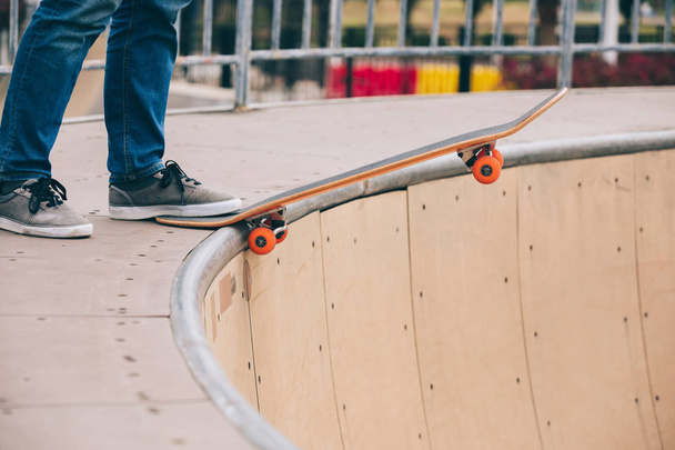 Cropped image of skateboarder practicing on skatepark ramp - Fotó, kép