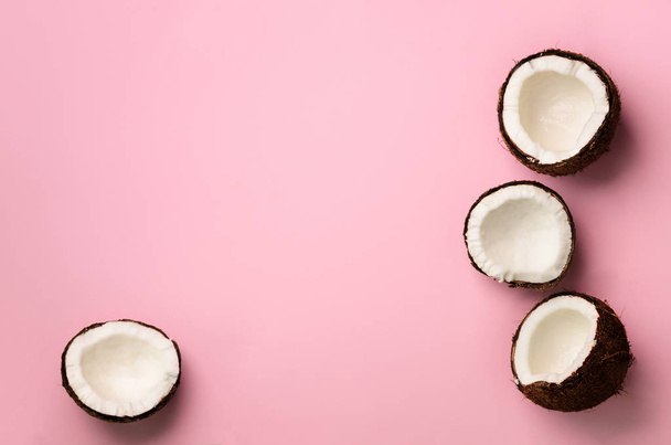 Pattern with ripe coconuts on pink background. Top View. Copy Space. Pop art design, creative summer concept. Half of coconut in minimal flat lay style. - Foto, imagen
