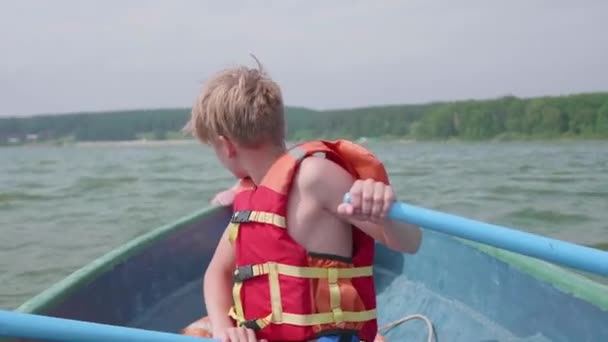 der Kerl schwimmt auf dem Boot. Teenager betreiben unabhängig voneinander ein Boot mit Hilfe von Rudern. Extremsport - Filmmaterial, Video