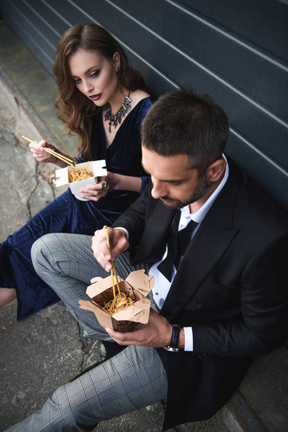high angle view of couple in fashionable clothing with asian takeaway food on street - Foto, Imagen