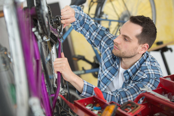 seller fixing bike in sport store - Foto, immagini