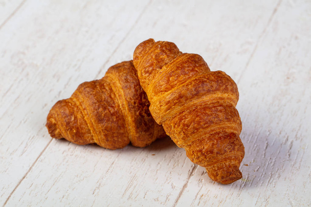 Sweet tasty croissant over wooden background - Photo, Image