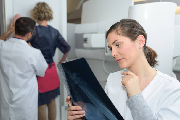 female doctor checking xray image  being very concerned - Foto, imagen