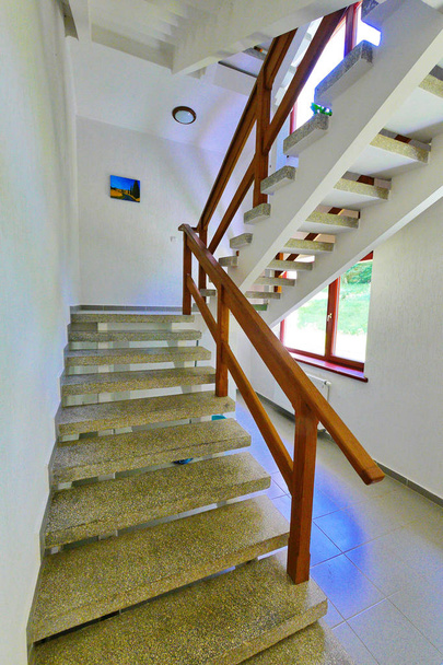 stone staircase with wooden railings and a picture between the floors - Photo, Image