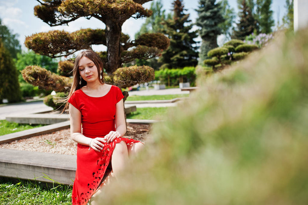 Teenage girl in red dress posed outdoor at sunny day. - Photo, image