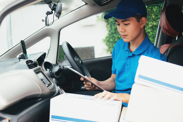 Leveren van de Service, Mailing en logistieke Concept.Young Delivery Man controle klantenlijst - Foto, afbeelding