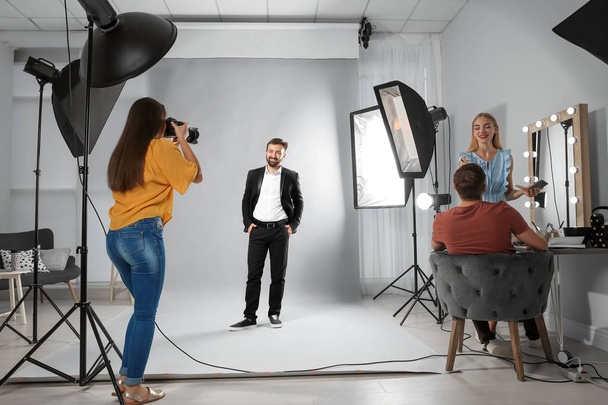 Professional team working with model in photo studio - Photo, image