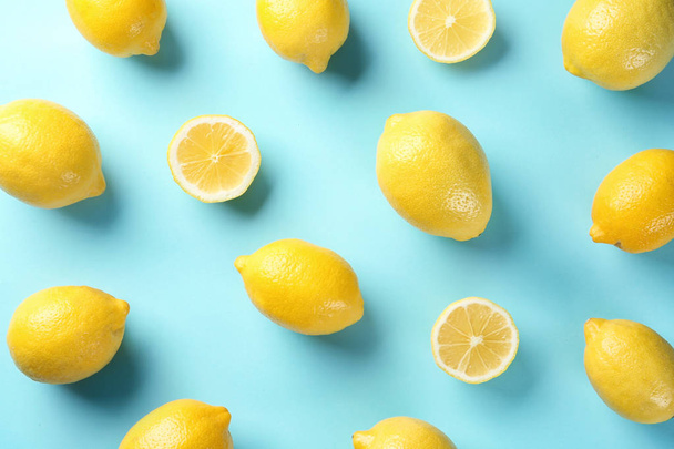 Flat lay composition with whole and sliced lemons on color background - Fotoğraf, Görsel