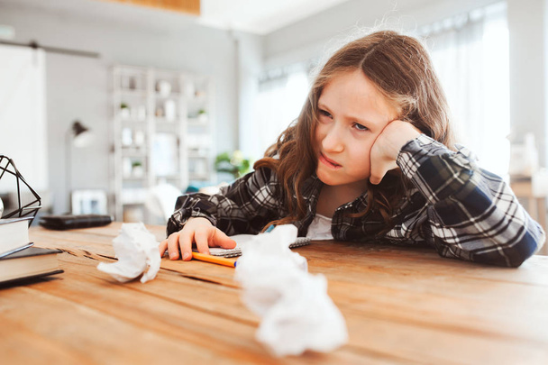 angry and tired child girl having problems with home work, throwing papers with mistakes. School and education concept. Difficult lessons.  - Foto, Imagen