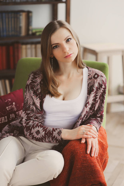 young woman relaxing at home with stack of books on background - Фото, зображення