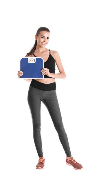 Happy young woman with scales on white background. Weight loss motivation - Fotó, kép
