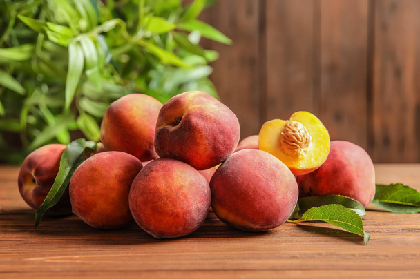 Свежие сладкие спелые персики на деревянном столе
 - Фото, изображение
