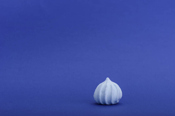 Blue meringue isolated on blue background with space for text - Foto, Imagen