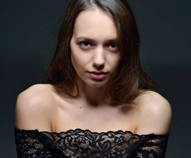 Portrait of the undressed beautiful woman t in black lace blouse. Studio shooting with dark background. - Foto, immagini