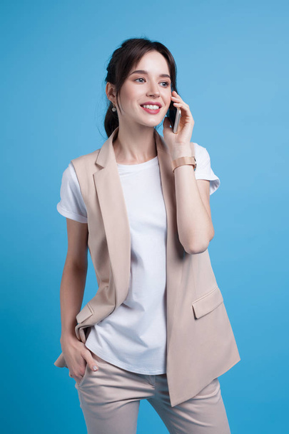 Beautiful successful young business woman on blue background. Business portrait - Фото, изображение