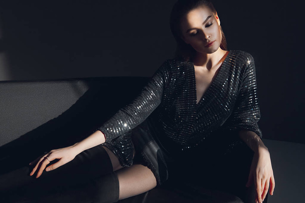 Young elegant girl in black shiny suit in sequins. Beauty portrait - Photo, Image