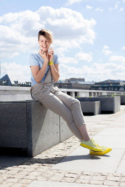 Young smiling woman on bridge on background of cityscape. Lifestyle portrait - Fotoğraf, Görsel