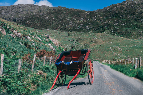 Un carruaje de caballos se encuentra en el pintoresco camino de Gap of Dunloe, un estrecho paso de montaña en el condado de Kerry, Irlanda, en un día soleado.
 - Foto, Imagen