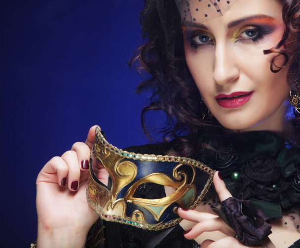 Portrait of woman with artistic make-up holding mask - Zdjęcie, obraz