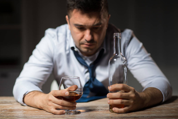 drunk man drinking alcohol at table at night - Φωτογραφία, εικόνα