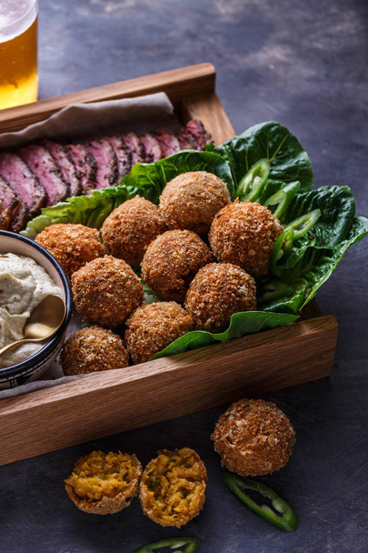 Falafel balls on a romano leafs in a wooden box - Photo, Image