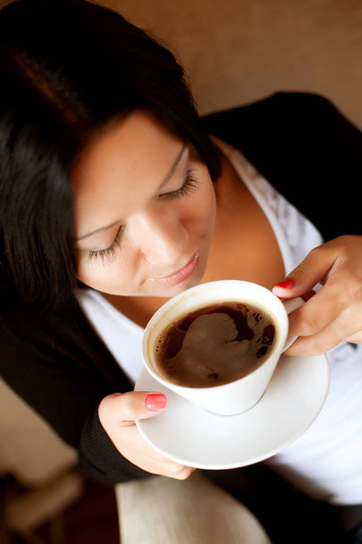 Jovem mulher sentada em um café bebendo café
 - Foto, Imagem