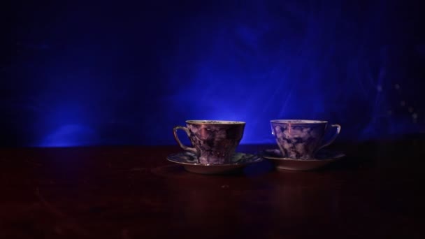 Tema conceptual de la ceremonia del café o té. Tetera o cafetera antigua de cerámica vintage con jarra de tazas y taza de azúcar sobre fondo tonificado oscuro con luz y humo. Espacio vacío para el texto. Slider tiro
 - Metraje, vídeo