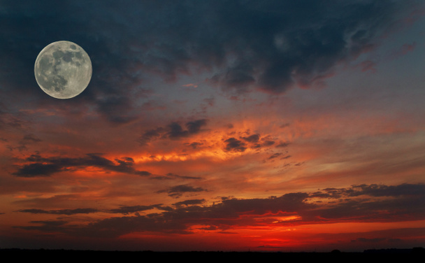Rudá obloha při západu slunce s velkou měsíc v úplňku fázi a silueta malé letadlo. obraz přírody - Fotografie, Obrázek