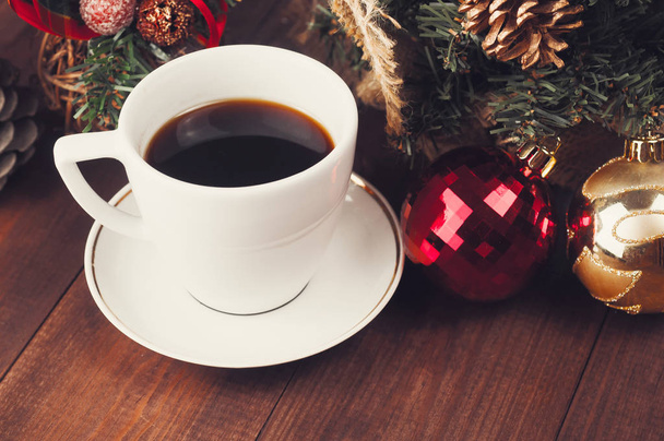 Close-up van de kerst kerstballen en kopje koffie. Bovenaanzicht van een kerst-werkplek. - Foto, afbeelding