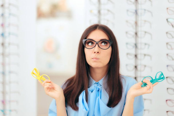 Fille Choisir les montures de lunettes de vue dans le magasin optique
 - Photo, image
