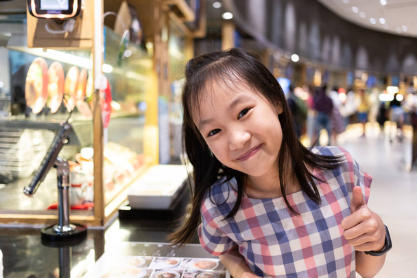 asiatisch süß mädchen glücklich und zufrieden bei food court in mall, lecker, lecker, schmeckt gut - Foto, Bild