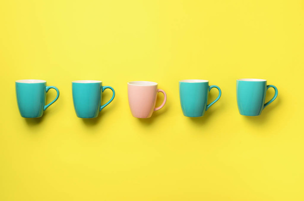 Pattern from blue and pink cups over yellow background. Birthday party celebration, baby shower concept. Punchy pastel colors. Minimalist style design - Φωτογραφία, εικόνα