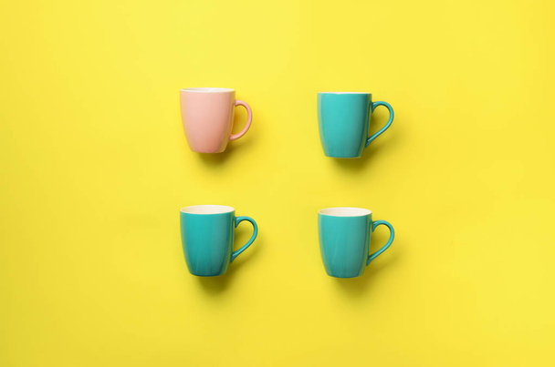 Pattern from blue cups over yellow background. Birthday party celebration, baby shower concept. Punchy pastel colors. Minimalist style design - Foto, Imagem
